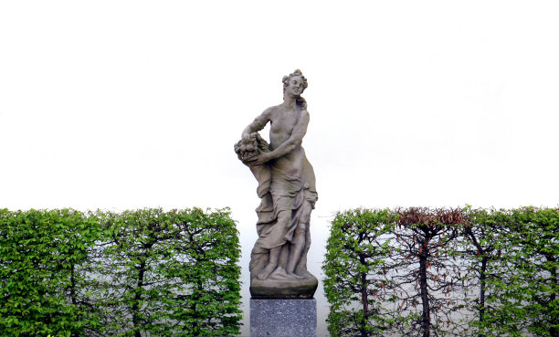 白色的经典雕像和灌木丛图片下载