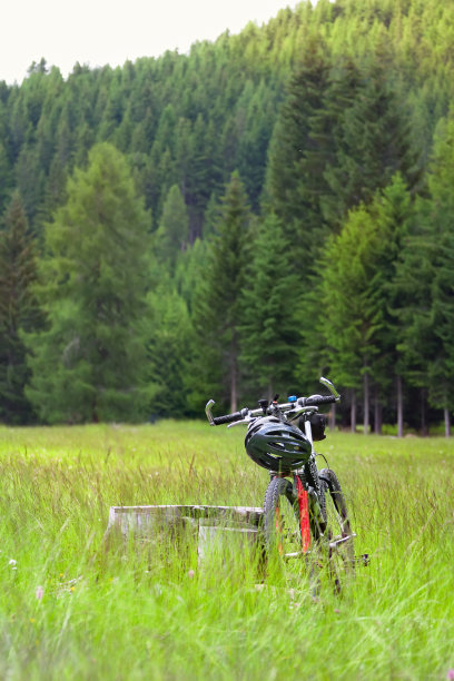 自行车在高山之间的田野里图片下载