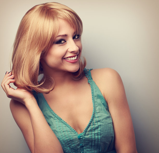 漂亮的金发短发，年轻女子露齿微笑图片下载