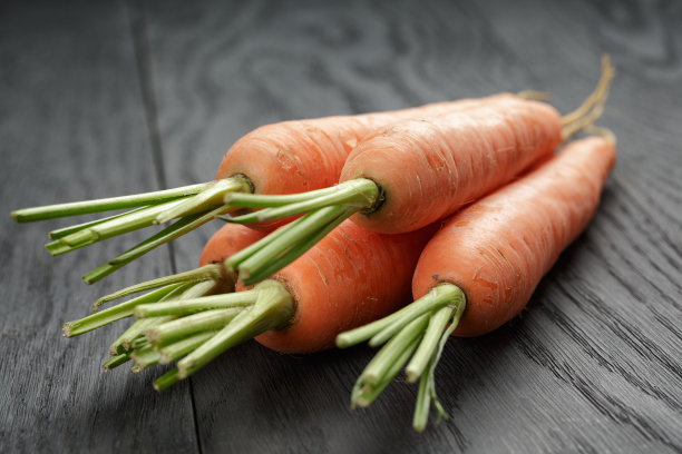 新鲜的胡萝卜放在旧橡木桌子上图片下载