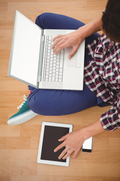 潮人坐在笔记本电脑上使用数字平板电脑图片下载