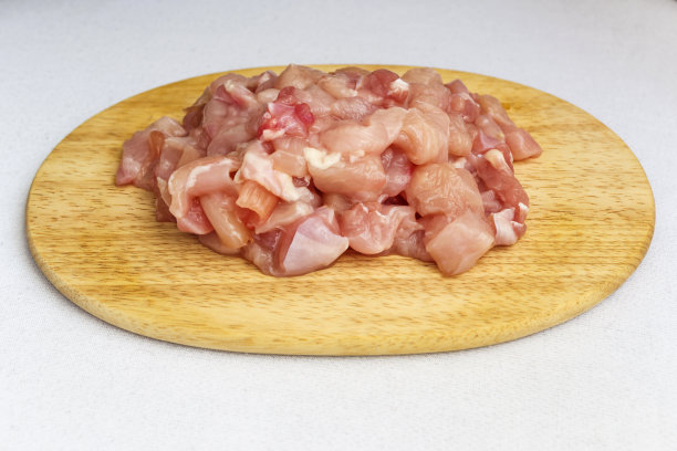 切菜板上白色背景的鸡块图片下载