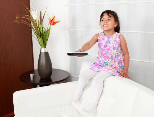 四岁的女孩坐在白色沙发上图片下载