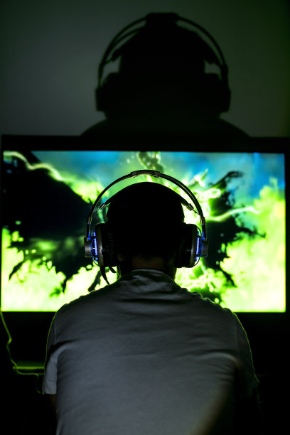 年轻玩家戴着耳机玩电子游戏。图片下载