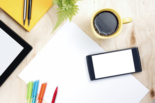 黑屏智能手机和平板电脑与财务办公供应在木制背景。图片下载