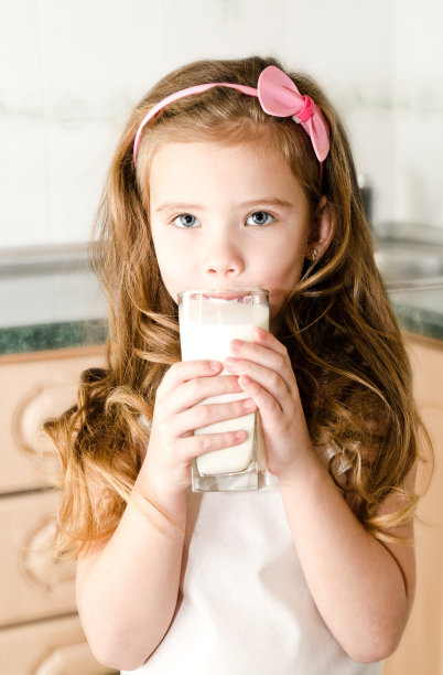 美丽微笑的小女孩喝着牛奶图片下载