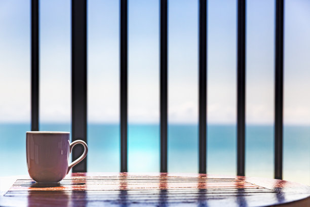 阳台木桌和木椅上放置咖啡杯，海景，休闲度假理念图片下载