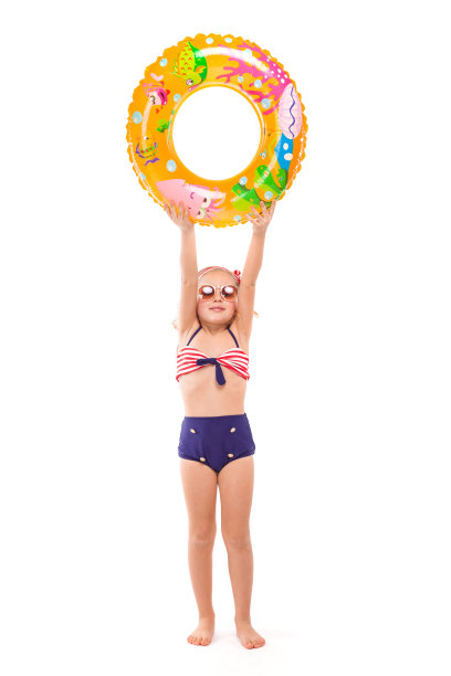 漂亮的小女孩穿着红条纹比基尼，蓝色的下装和粉红色的花环站着，腰上戴着五颜六色的橡胶圈图片下载