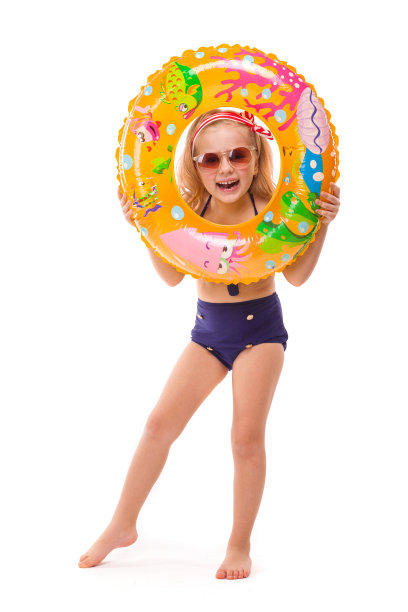 漂亮的小女孩穿着红色条纹比基尼，蓝色下装，戴着太阳镜和粉红色的花环，手里拿着橡胶戒指图片下载