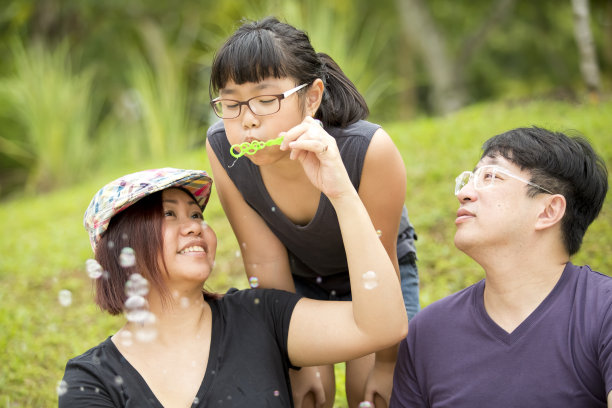 一个年轻的亚洲女孩在玩吹泡泡图片下载