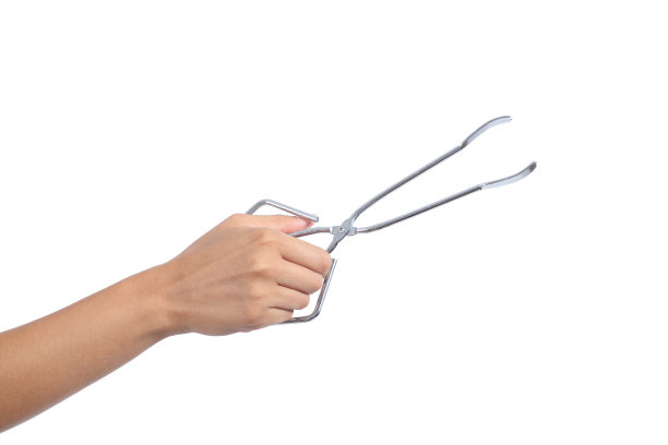 女人手里拿着一把打开的厨房钳子图片下载