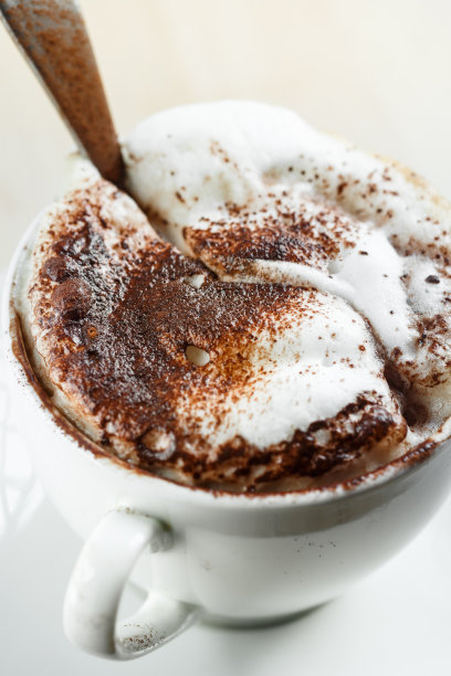 卡布奇诺和勺子放在桌上图片下载