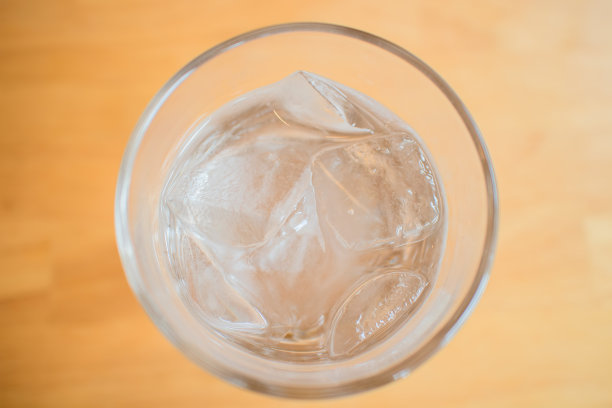 在木桌上用玻璃杯盛水和冰块图片下载
