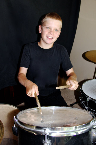 金发男孩黑衬衫打鼓微笑图片下载