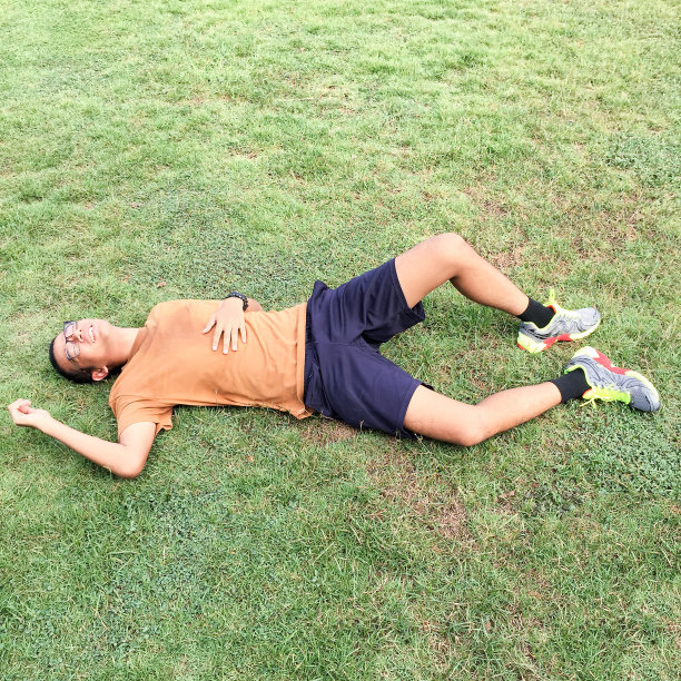 年轻人躺在绿草地上图片下载