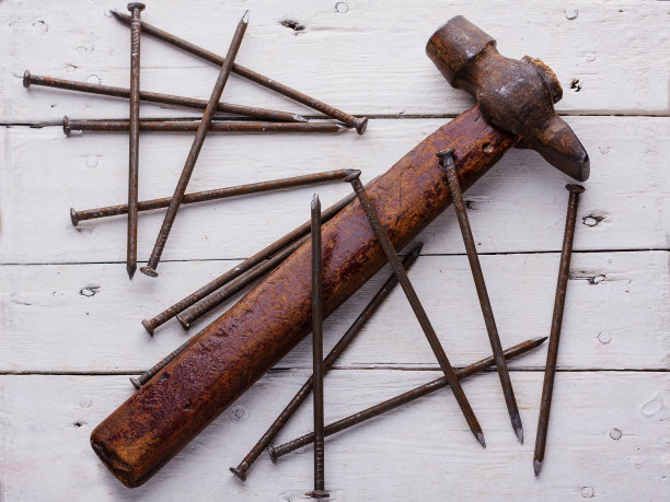 白色木板上的旧锤子和钉子图片下载