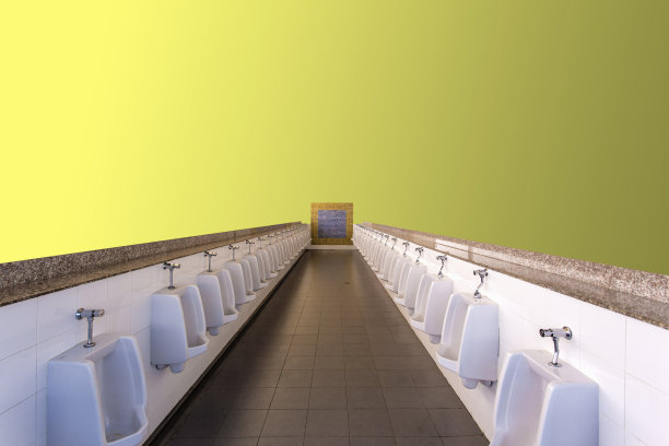 黄色背景的小便池。图片下载