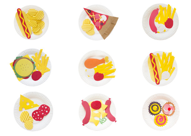 一套9个盘子的快餐。热狗，薯条，披萨，汉堡包，薯条，鸡肉，意大利腊肠，意大利面，香肠，纸杯蛋糕，彩色纸放在一次性盘子上图片下载