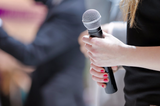 女人拿着麦克风站在舞台上图片下载