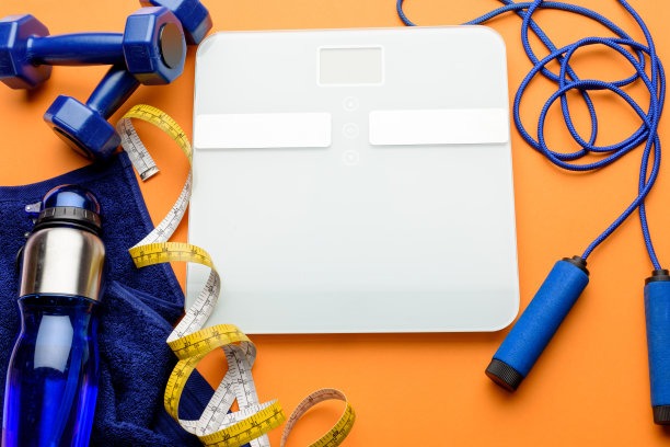 各种运动器材、卷尺和毛巾隔离在橙色上图片下载