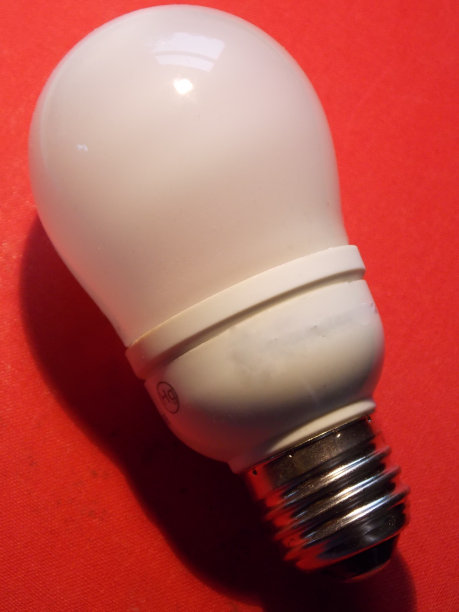 垂直格式-“红色背景上的隔离CFL灯泡”图片下载