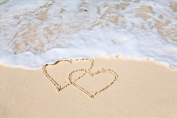 两颗心画在沙滩上，被海浪抹去图片下载