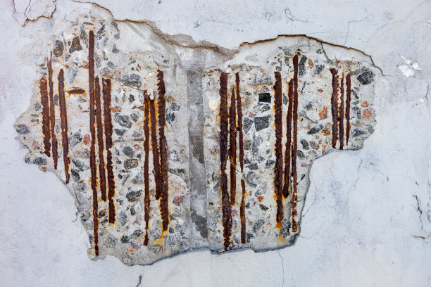 灰泥墙上的洞有可见的钢筋。图片下载