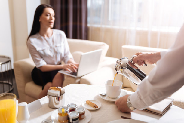 专业的男服务生往杯子里倒咖啡图片下载