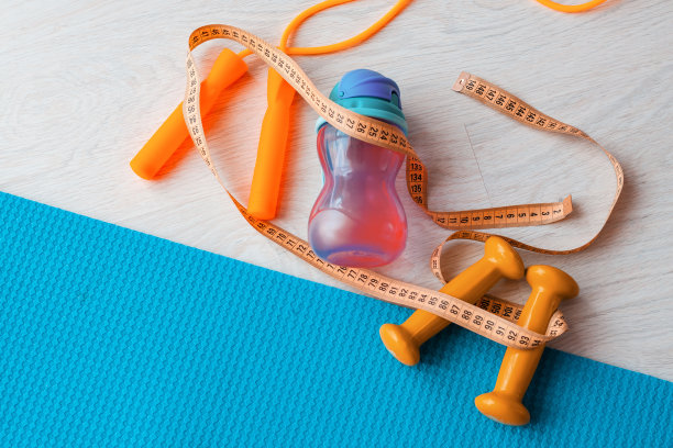 健身概念-瑜伽垫，哑铃，跳绳，水瓶和卷尺图片下载