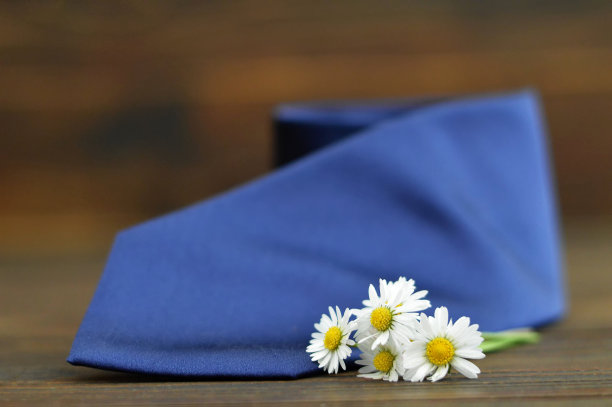 父亲节贺卡:蓝色领带和春天的花朵木制背景图片下载