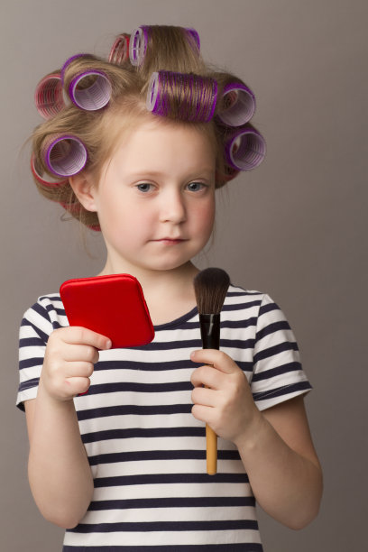 戴着卷发器的小女孩的肖像图片下载