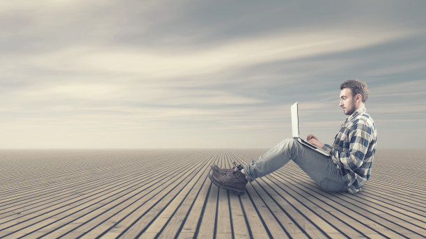 一个年轻人坐在木地板上图片下载