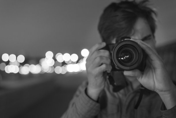 男摄影师肖像在街道与散景灯图片下载