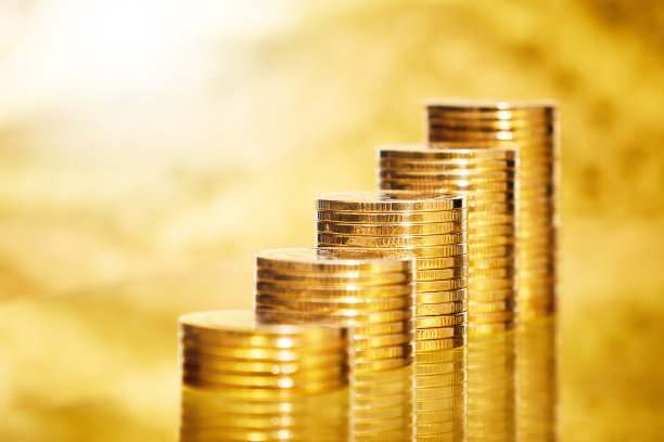 模糊的金色背景上堆放着硬币图片下载
