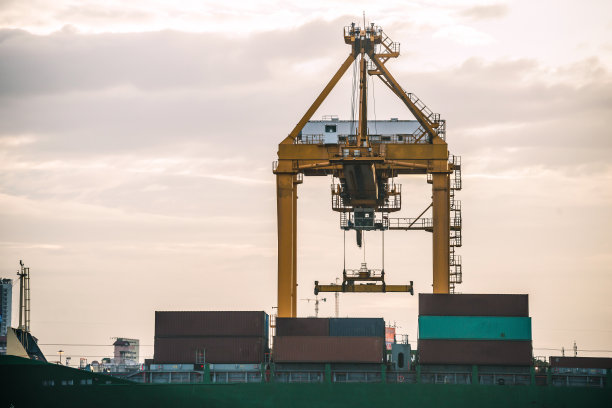 由港口起重机吊起的海上集装箱图片下载