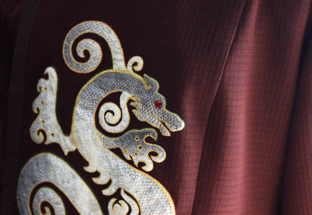 亚洲的中国龙，用鱼皮在葡萄酒织物上制作而成。装饰用珍贵的红钻石制成的红眼龙。亚洲民族传统服饰的象征图片下载