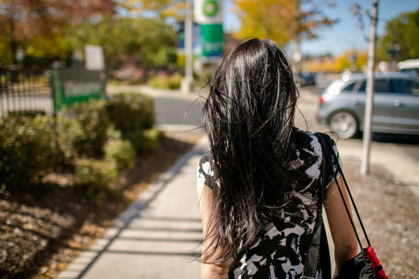 漂亮的黑发女孩在走路。图片下载