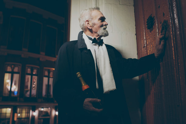穿着燕尾服，开着香槟的男人晚上来敲门。图片下载