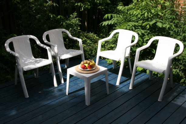 院子里有四把白色的椅子和一张小桌子图片下载