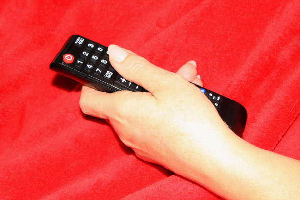 女人拿着电视遥控器图片下载