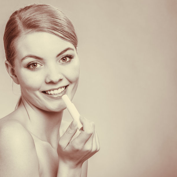 年轻女子在嘴唇上涂唇膏。图片下载