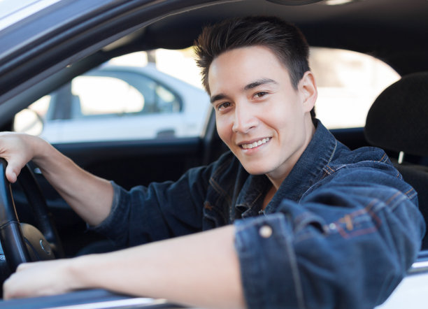 一个穿着牛仔夹克开车的年轻人图片下载