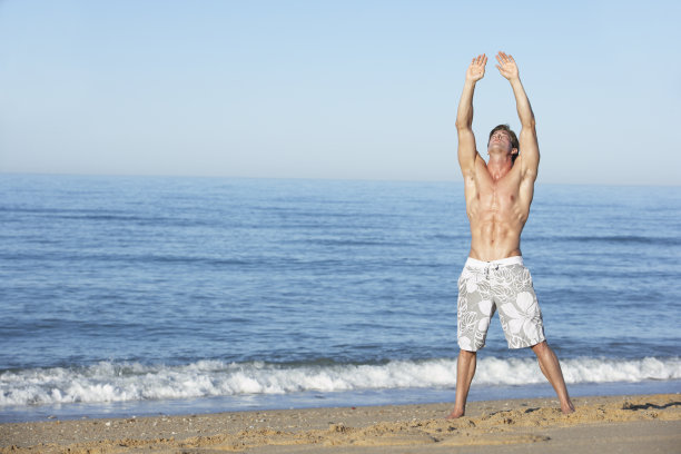 站在夏日海滩上的年轻人图片下载