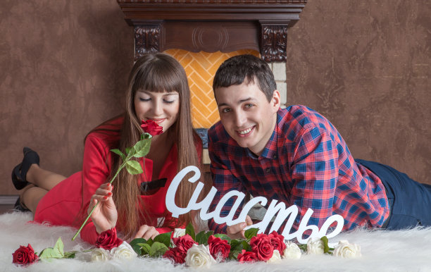 一对相爱的年轻夫妇躺在壁炉旁的地毯上图片下载