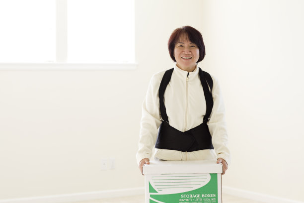 成年亚洲妇女搬运移动箱子在白色空房间图片下载
