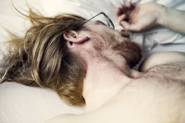 红头发的年轻人在床上睡觉图片下载