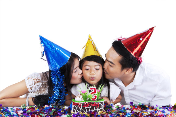 父母在生日聚会上亲吻他们的孩子图片下载