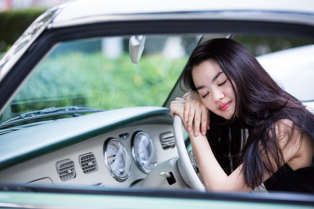 坐在老爷车里微笑的亚洲女人图片下载