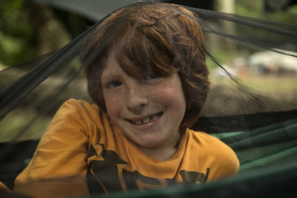 红发男孩躺在吊床上图片下载