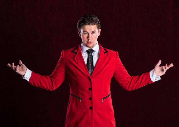 优雅微笑的年轻英俊的男子在红色西装图片下载